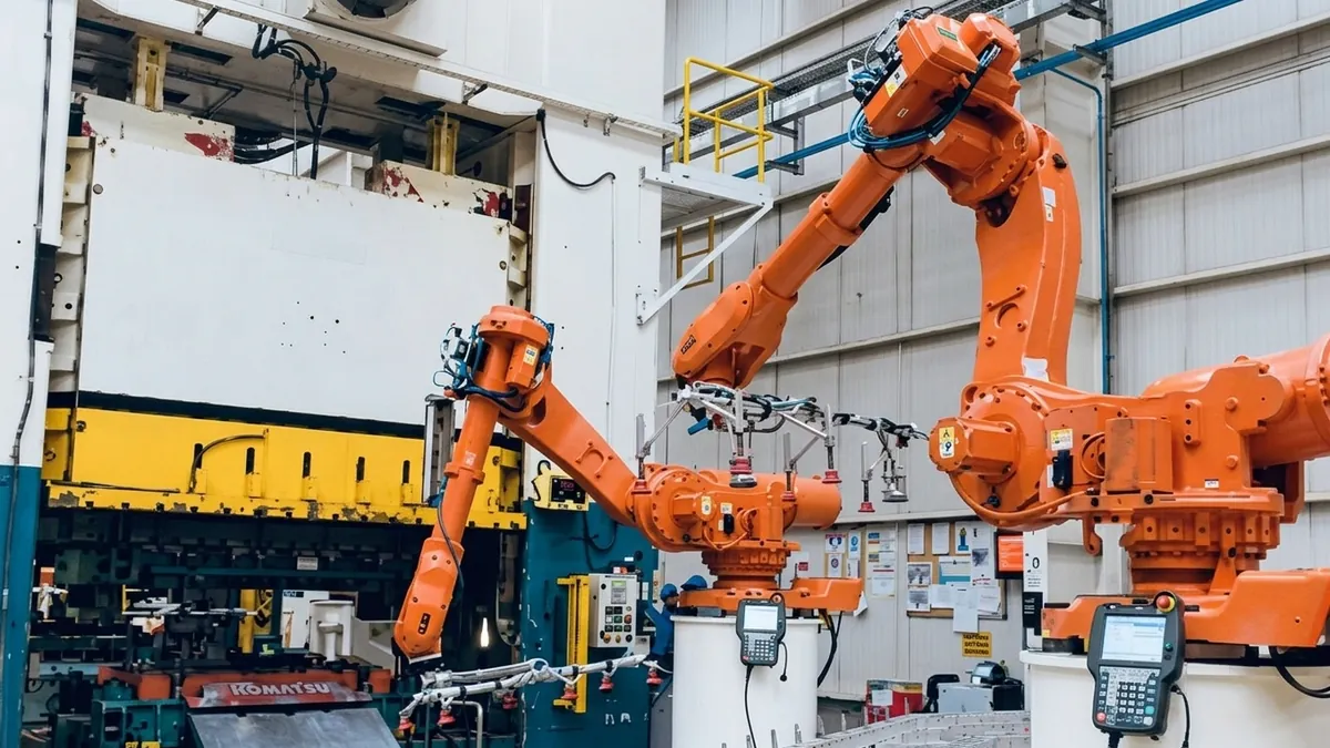 Robôs industriais alimentando prensa de estampagem em linha de conformação